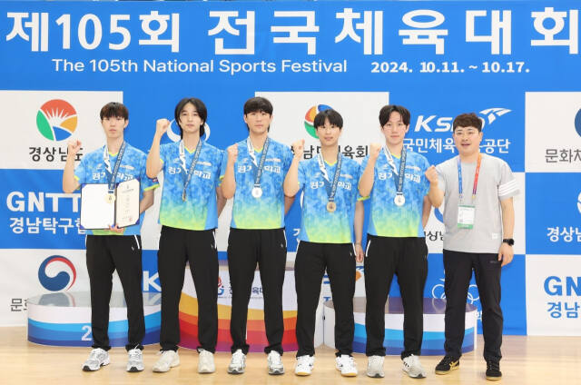 제105회 전국체전 탁구 남자 대학부 단체전서 2연패를 달성하며 시즌 4관왕에 오른 경기대의 이재욱 감독(오른쪽)과 선수들이 금메달을 목에 걸고 기념촬영을 하고 있다.경기대 제공