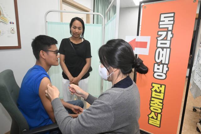 20일 오전 경기도의료원 수원병원 노동자 건강증진센터에서 언어장벽으로 의료 접근성이 낮은 외국인 노동자들이 독감(인플루엔자) 백신 예방접종을 받고 있다. 센터는 한국어 소통이 어려운 외국인 노동자들을 위해 다양한 언어의 문진표를 마련하고 외국인 노동자 지원센터에서 통역 서비스를 지원했다.조주현기자