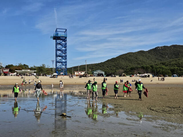 ㈔한국곰두리봉사회 인천영종지회 회원들이 지역 장애인들과 함께 하나개 해수욕장을 거닐며 환경정화 활동을 벌이고 있다. 곰두리 봉사회 제공