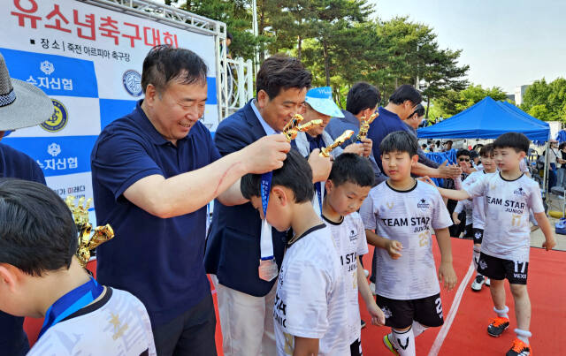 지난 5월18일 죽전 아르피아 축구장에서 열린 제8회 수지신협배 유소년축구대회에 참가한 유소년 선수들이 메달을 받고 있다. 수지신협 제공