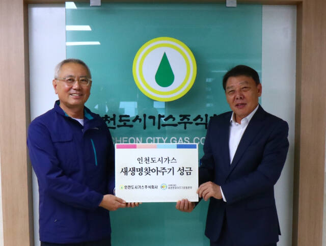 이상규 인천도시가스 경영지원담당상무이사(왼쪽)가 박준용 새생명찾아주기운동본부장에게 성금을 전달한 뒤 기념촬영을 하고 있다. 새생명찾아주기운동본부 제공