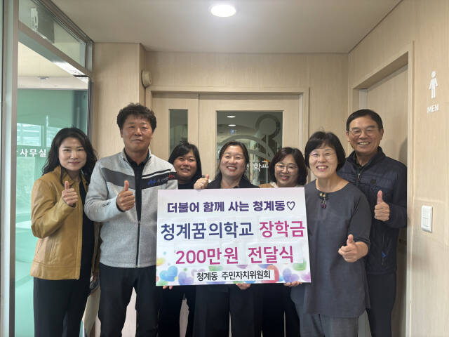최승규 의왕시 청계동 주민자치위원장(왼쪽에서 두 번째)과 위원, 정경애 청계동장(가운데) 등이 청계꿈의학교에 장학금을 전달하고 기념사진을 찍고 있다. 의왕시 제공