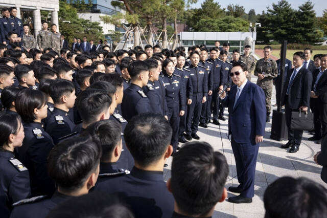 윤석열 대통령이 지난 25일 서울 용산 대통령실에서 견학 온 공군사관학교 4학년 생도들을 격려한 뒤 동행한 공군사관학교 영관급 및 위관급 장교들과 기념촬영을 하고 있다. 연합뉴스