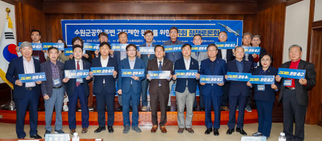 이재준 수원시장(앞줄 가운데)과 민주당 국회의원 등이 국회도서관 소회의실에서 ‘수원 군 공항 주변 고도 제한 완화’를 주제로 정책 토론회를 열고 기념촬영을 하고 있다. 수원시 제공