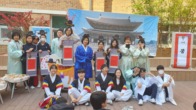 양주 옥빛중학교에서 조선시대 과거시험을 재현한 옥빛별시에서 입상한 학생들이 장원숙 교장과 함께 기념사진을 찍고 있다. 옥빛중학교 제공