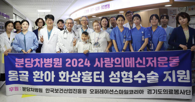 분당차병원 의료진이 화상 후유증으로 힘들어하던 몽골 소년 바야르 군(10)을 초청해 안면 성형 수술을 안전하게 마쳤다. 사진은 차병원 의료진이 바야르군과 바야르군 어머니와 함께 사진을 촬영하고 있는 모습. 분당차병원 제공