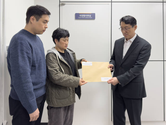 양주시의회 파행 정상화 촉구를 위한 시민사회연대모임 오옥분 공동대표가 최명훈 의회 사무과장에게 시의회 정상화를 촉구하는 시민들의 서명부를 전달하고 있다. 이종현기자