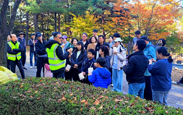 지난 2일 오전 용인시 기흥구 영덕동 흥덕마을13단지 관리사무소 앞 광장에서 열린 주민 화합 가을 잔치에 참석한 아파트 주민들이 숲해설사의 설명을 듣고 있다. 흥덕마을13단지 입주자대표회의 제공