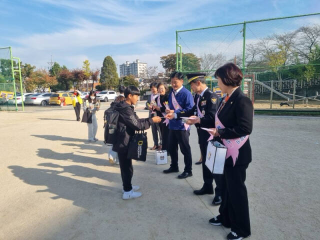 5일 수원특례시 팔달구에 있는 화홍초등학교에서 사이버 범죄 예방 캠페인이 진행된 가운데 박영대 수원중부경찰서장이 한 학생에게 홍보물을 전달하고 있다. 수원중부경찰서 제공