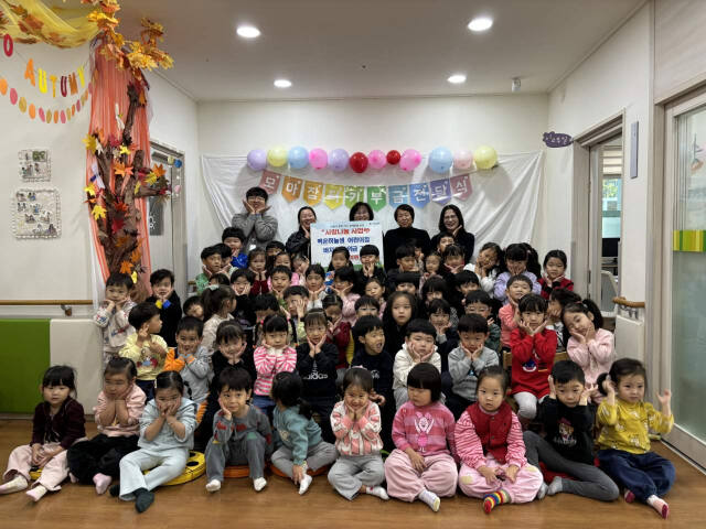 의왕시 청계동 백운하늘샘어린이집이 바자회를 운영해 모은 성금을 청계동 주민센터에 전달하고 어린이들과 기념촬영을 하고 있다. 의왕시 제공