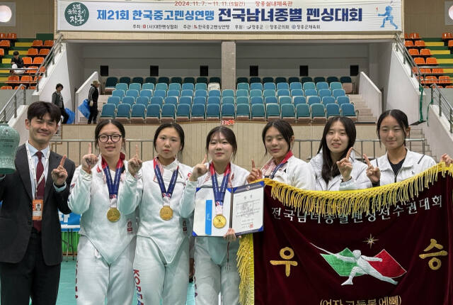 제21회 한국중·고연맹 전국남녀종별펜싱선수권대회 여고부 에페서 우승, 시즌 4관왕에 오른 화성 향남고 선수들이 홍용기 코치와 우승기를 앞세우고 기념촬영을 하고 있다.향남고 제공