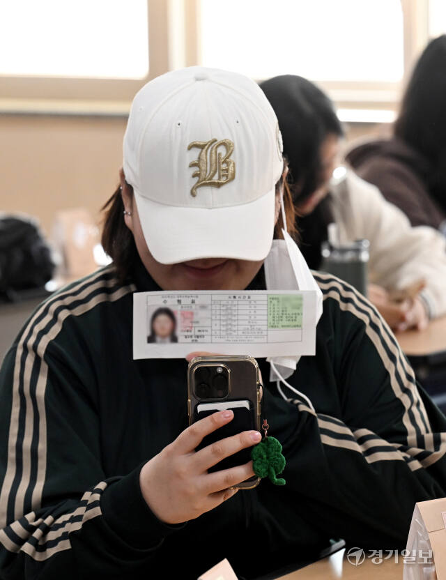 2025학년도 대학수학능력시험 예비소집일인 13일 인천 미추홀구 인화여자공등학교에서 한 수험생이 수험표를 받고 기념촬영을 하고 있다. 조병석기자