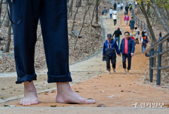 13일 오후 군포시 수리산 산림욕장 황톳길에서 시민들이 맨발로 산책을 하고 있다. 경기도는 이날 ‘경기 흙향기 맨발길 1천개 조성’ 선포식을 가졌다. 윤원규기자