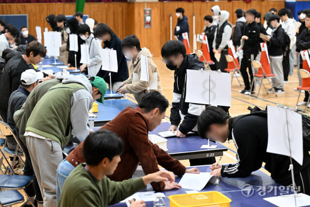 2025학년도 대학수학능력시험을 하루 앞둔 13일 오전 예비소집이 진행된 수원북중 체육관에서 수험생들이 본인 확인 절차 후 수험표를 받고 있다. 김시범기자