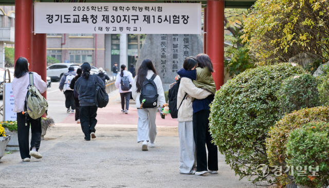 2025학년도 대학수학능력시험일인 14일 오전 경기도교육청 제30지구 제15시험장이 마련된 수원 태장고등학교로 한 수험생이 부모님의 격려를 받으며 들어가고 있다. 윤원규기자