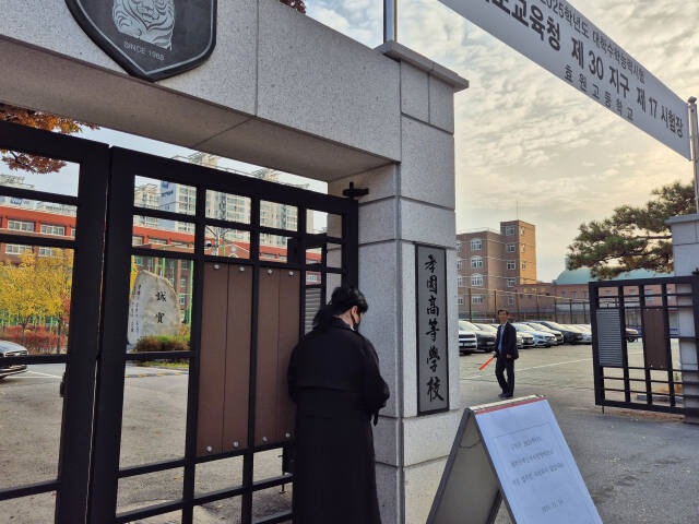 2025학년도 수능일인 14일 오전 7시40분께 경기도교육청 제30지구 제17시험장 수원특례시 영통구 효원고등학교 정문 앞에서 학부모 한 명이 문 앞에서 기도하고 있다. 김한울기자