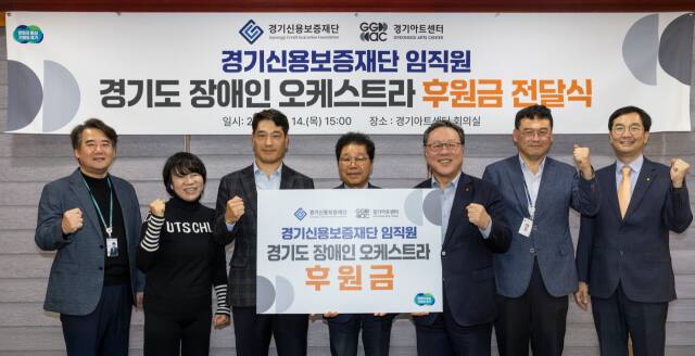 경기신용보증재단이 14일 경기도장애인오케스트라에 1천만원의 지원금을 전달한 뒤 기념촬영을 하고 있다. 경기신보 제공.