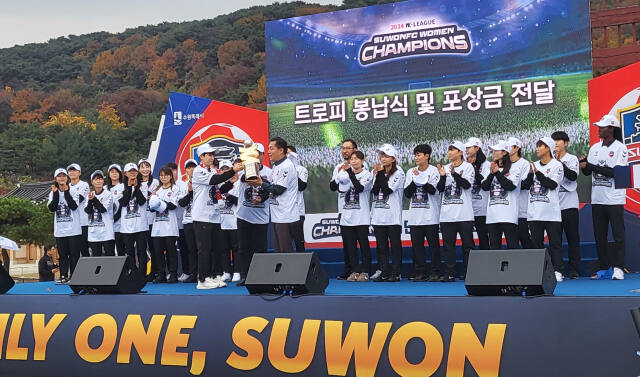 여자축구 ‘디벨론 2024 WK리그’ 챔피언 수원FC 위민의 시민과 함께하는 팬페스타 행사에서 박길영 감독과 주장 문미라가 이재준 수원특례시장(오른쪽)에게 우승트로피를 전달하고 있다.황선학기자