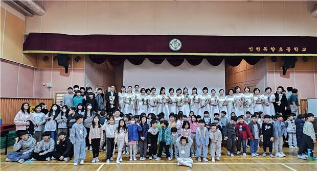 인천여성가족재단 문화예술단 합창단이 지난 15일 인천 서구에 있는 인천목향초등학교 강당에서 초등학생 200여명을 대상으로 ‘찾아가는 음악회’ 공연을 마치고 기념촬영을 하고 있다. 재단 제공