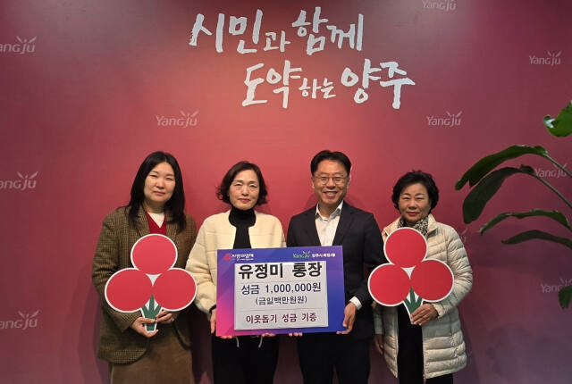 지난 20일 양주시 옥정2동 행정복지센터를 방문한 유정미 양주시 옥정2동 옥정21통장이 이운규 동장에게 성금을 전달하고 기념사진을 찍고 있다. 옥정2동 제공