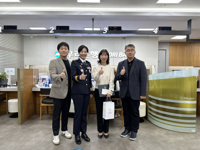 지난 19일 우리은행 동탄테크노밸리지점에서 화성동탄경찰서 관계자들이 보이스피싱 인출책 검거에 기여한 직원에게 감사장을 수여하고 기념촬영을 하고 있다. 화성동탄경찰서 제공