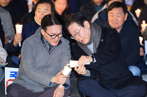 더불어민주당 이재명 대표가 23일 오후 서울 종로구 광화문 북측광장 인근에서 열린 ‘김건희·윤석열 국정농단 규탄·특검 촉구 제4차 국민행동의 날’ 집회에 참석해 김민석 최고위원과 촛불을 나누고 있다. 연합뉴스