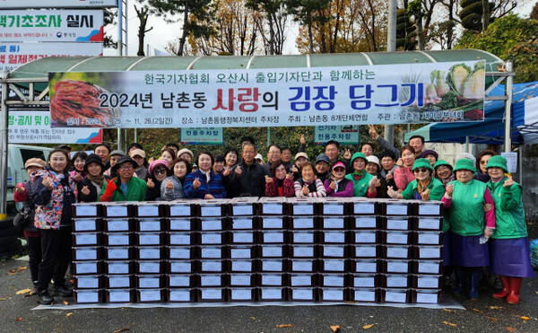 오산 남촌동 8개 단체 회원들이 김장김치를 담근후 기념사진능 촬여하고 있다. 강경구 기자