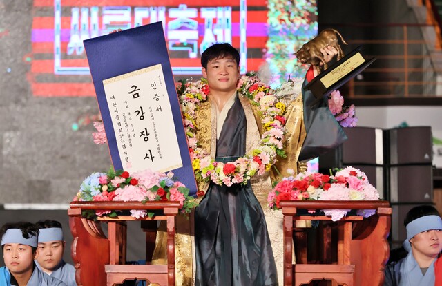 30일 영암실내체육관에서 열린 2024 천하장사 대축제 금강급 장사결정전서 최정만(영암군민속씨름단)을 3-1로 누르고 우승한 김기수(수원특례시청)가 장사인증서와 황소트로피를 들고 꽃가마에 올라 행진하고 있다.대한씨름협회 제공