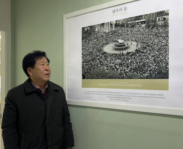 4일 오전 수원특례시 팔달구 화서동에 있는 5·18민주화운동부상자회 경기도지부에서 김장덕 사무국장이 ‘광주의봄’ 사진을 보며 과거를 떠올리고 있다. 박소민기자