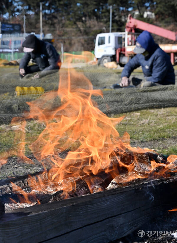 경기지역이 올겨울 들어 가장 추운 날씨를 보인 18일 오전 화성시 궁평항 인근 야외 작업장에서 어민들이 모닥불을 피운 채 작업하고 있다. 혼란한 정국 속에 추위까지 찾아오면서 서민들이 느끼는 체감온도는 더욱 낮아질 것으로 보인다. 김시범기자