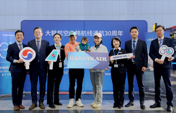 지난 22일 베이징 서우두 국제공항에서 KE2202편 30번째 탑승수속 승객인 리우 지아시(LIU JIAXI)씨(오른쪽에서 네 번째)가 한국행 왕복 비즈니스 항공권 1매를 전달 받고 대한항공 관계자들과 기념사진을 촬영하고 있다. 대한항공 제공