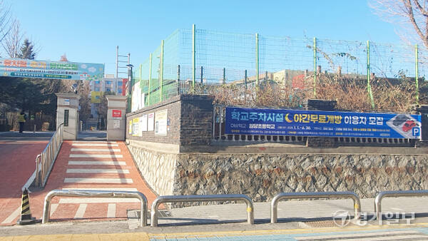 고양특례시 학교 주차시설 야간 무료개방 참여 학교 중 한곳인 덕양구 주교동 원당초등학교 입구에 이용자 모집 안내 현수막이 걸려 있다. 신진욱기자