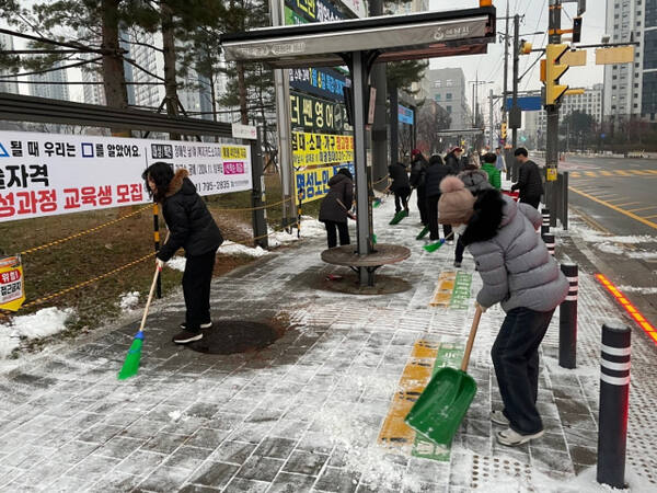 하남 시민들이 버스정류장에서 눈을 치우고 있다. 하남시 제공