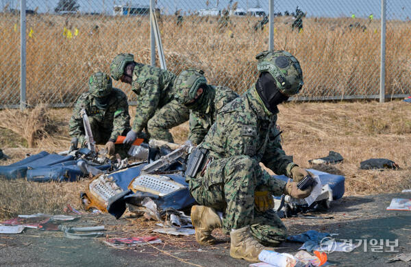 30일 오전 무안 국제공항 사고현장에 사고 희생자들을 추모하는 국화꽃이 놓여있다. 윤원규기자 30일 오전 무안 국제공항 사고현장에서 특수전 사령부 소속 군인들이 헨드폰 등 유류품 등을 수거하고 있다. 윤원규기자