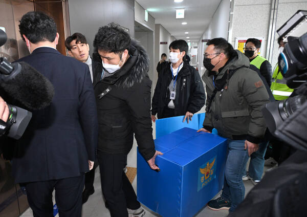 지난 2일 전남 무안군 무안국제공항 운영부 사무실에서 압수수색을 마친 경찰 관계자들이 박스를 들고 나서고 있다. 연합뉴스