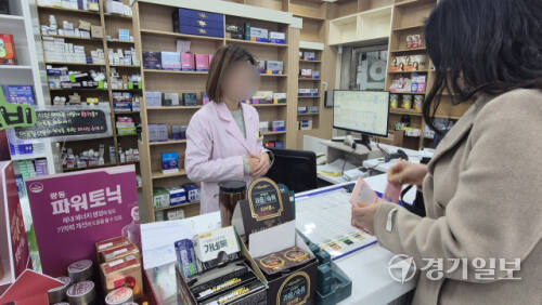 8일 오전 용인시 수지구 풍덕천동의 한 약국에서 마스크를 낀 소비자가 성인용 종합감기약을 구매하고 있다. 금유진기자