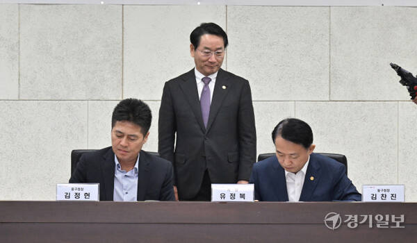 김정헌 인천 중구청장(왼쪽)이 김찬진 동구청장(오른쪽), 유정복 인천시장과 함께 중구-동구 '제물포구 출범을 위한 공동합의문 체결식'에서 합의안에 서명하고 있다.