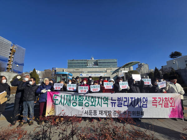 15일 서둔동 재개발추진위원회가 수원시청 앞에서 기자회견을 열고 뉴빌리지 사업 철회와 재개발 연번 부여를 촉구하고 있다. 황호영기자
