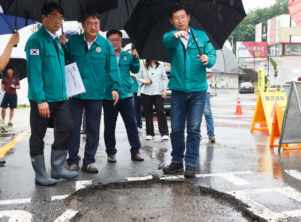 지난해 7월18일 기흥구 중동 동백3동 행정복지센터 신축 현장을 찾은 이상일 용인특례시장(오른쪽)이 폭우로 파손된 도로 피해 상황을 확인하고 있다. 용인특례시 제공
