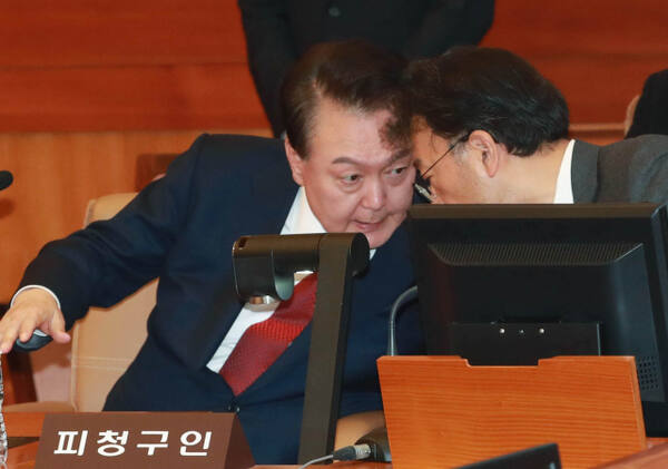 윤석열 대통령이 지난 21일 오후 서울 종로구 헌법재판소에서 열린 탄핵심판 3차 변론에 출석해 차기환 변호인과 대화하고 있다. 연합뉴스