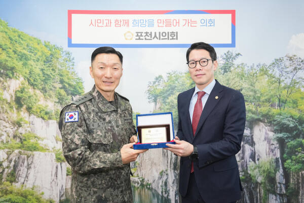 임종훈 포천시의회 의장(오른쪽)이 6일 시의회를 방문한 김성민 5군단장으로부터 육군 참모총장 감사패를 전수하고 있다. 포천시의회 제공