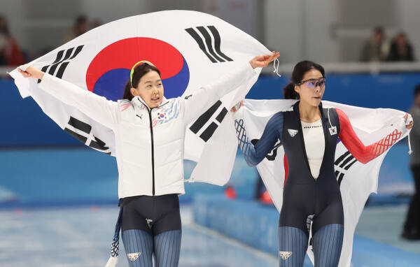 9일 중국 하얼빈 헤이룽장 빙상훈련센터 스피드스케이팅 오벌에서 열린 스피드스케이팅 여자 500ｍ에서 금메달을 획득한 김민선(왼쪽)이 2위를 차지한 후배 이나현과 태극기를 두르고 빙판을 돌고 있다.연합뉴스