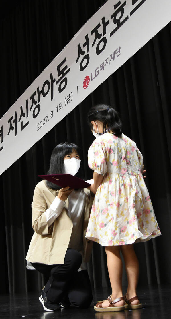 구연경 LG복지재단 대표이사가 2022년 8월 19일 서울 마곡 LG사이언스파크에서 열린 ‘저신장아동 성장호르몬제 기증식’에서 한 어린이에게 기증서를 전달하고 있다.