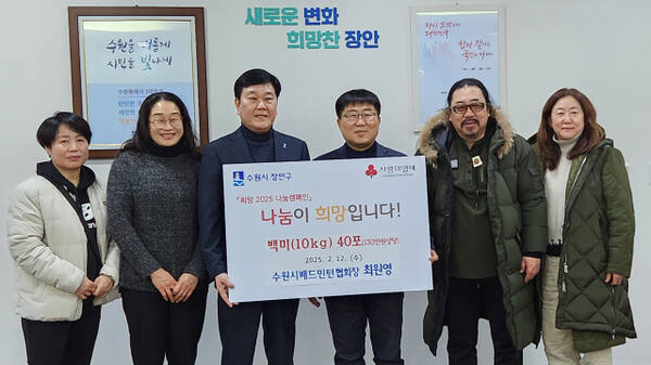 최원영 수원시배드민턴협회장(오른쪽 3번째)이 취임식 때 축하 화환대신 받은 백미를 이상수 수원 장안구청장에게 전달하고 있다.수원시배드민턴협회 제공