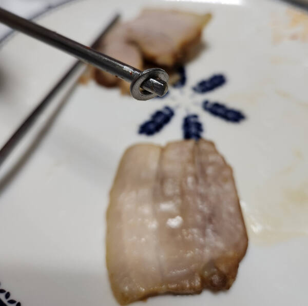 A씨가 족발을 먹던 중 씹었다고 주장하는 지름 1㎝ 원형 쇳조각. A씨 제공