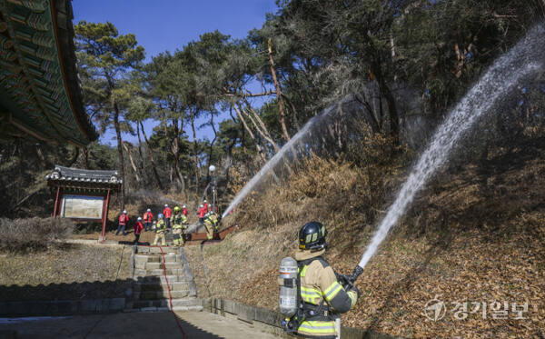 20일 오후 여주시 신륵사에서 열린 '산림화재 대응 및 문화유반 보호·반출 훈련'에서 소방대원과 여주시 산불진화 대원들이 산불 발생 상황을 가정해 방어선 구축 및 진화 훈련을 하고 있다. 윤원규기자