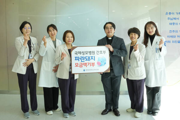 국제성모병원 간호부 관계자들이 파란돼지 저금통 모금액을 기부하며 기념촬영을 하고 있다. 국제성모병원 제공