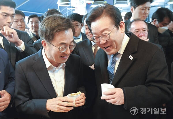 지난해 더불어민주당 이재명 대표(오른쪽)와 김동연 경기도지사가 수원특례시 못골시장을 찾아 호떡을 먹으며 대화하고 있다. 경기일보DB