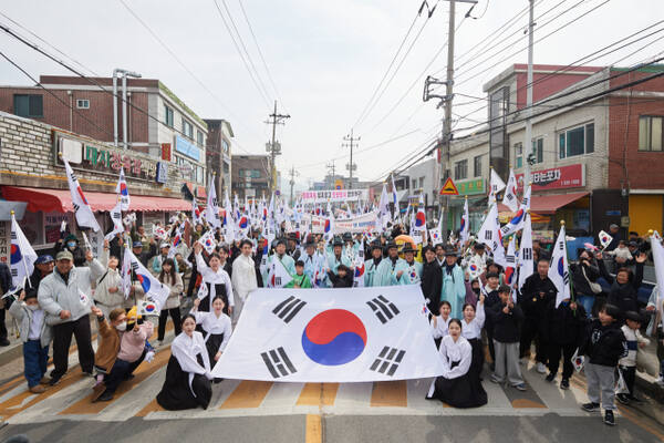 1일 광적면 가래비시장 도로에서 3.1만세운동을 재현하는 행사에 참가한 많은 시민들이 태극기 앞에서 기념사진을 찍고 있다. 양주시 제공