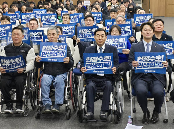더불어민주당 경기도당 홍보소통위원장을 맡은 황대호 위원장(오른쪽)과 참석자들이 손팻말을 들고 구호를 외치고 있다. 김경희기자